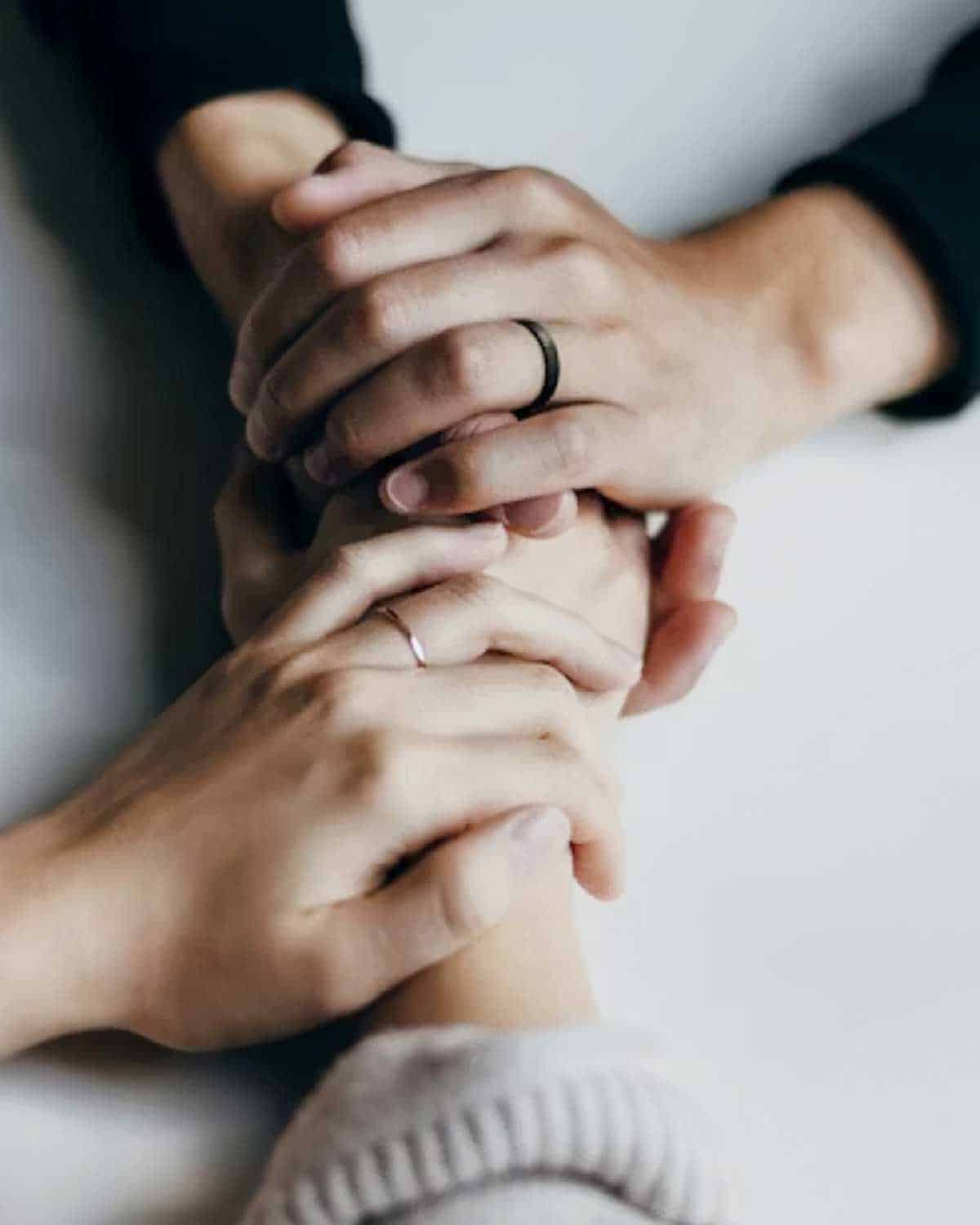 Two pairs of hands held together